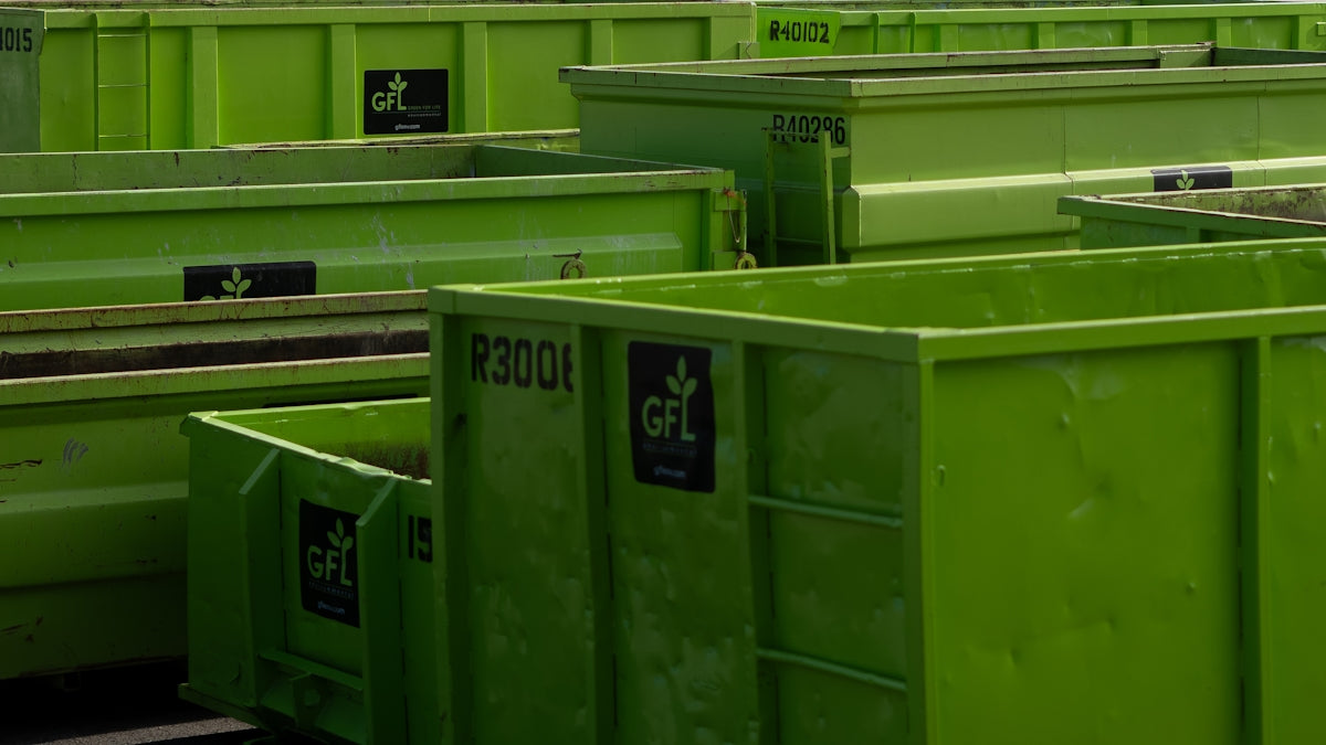 a group of green trash cans sitting next to each other