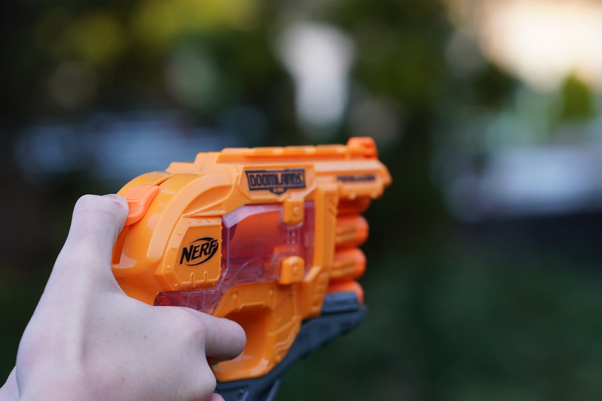a close up of a person holding a nerf gun