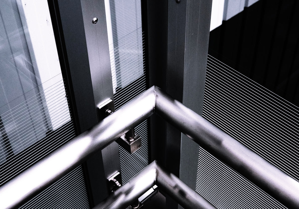 a black and white photo of a metal railing