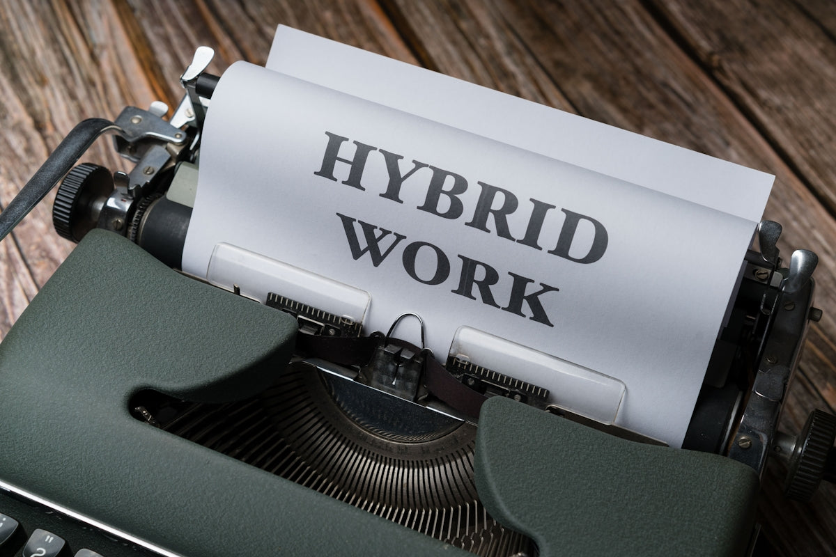 a typewriter with a sheet of paper that reads hybrid work