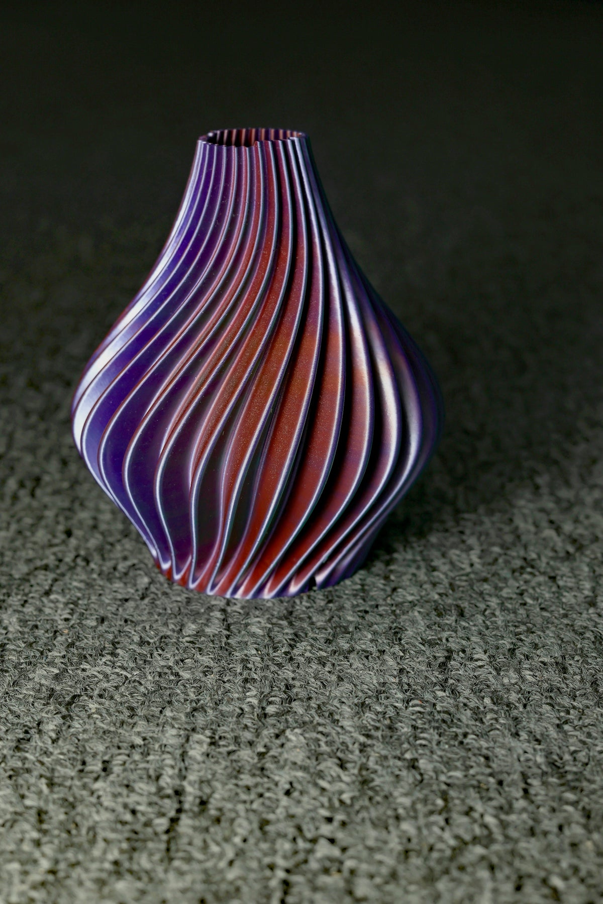 a purple vase sitting on top of a gray floor