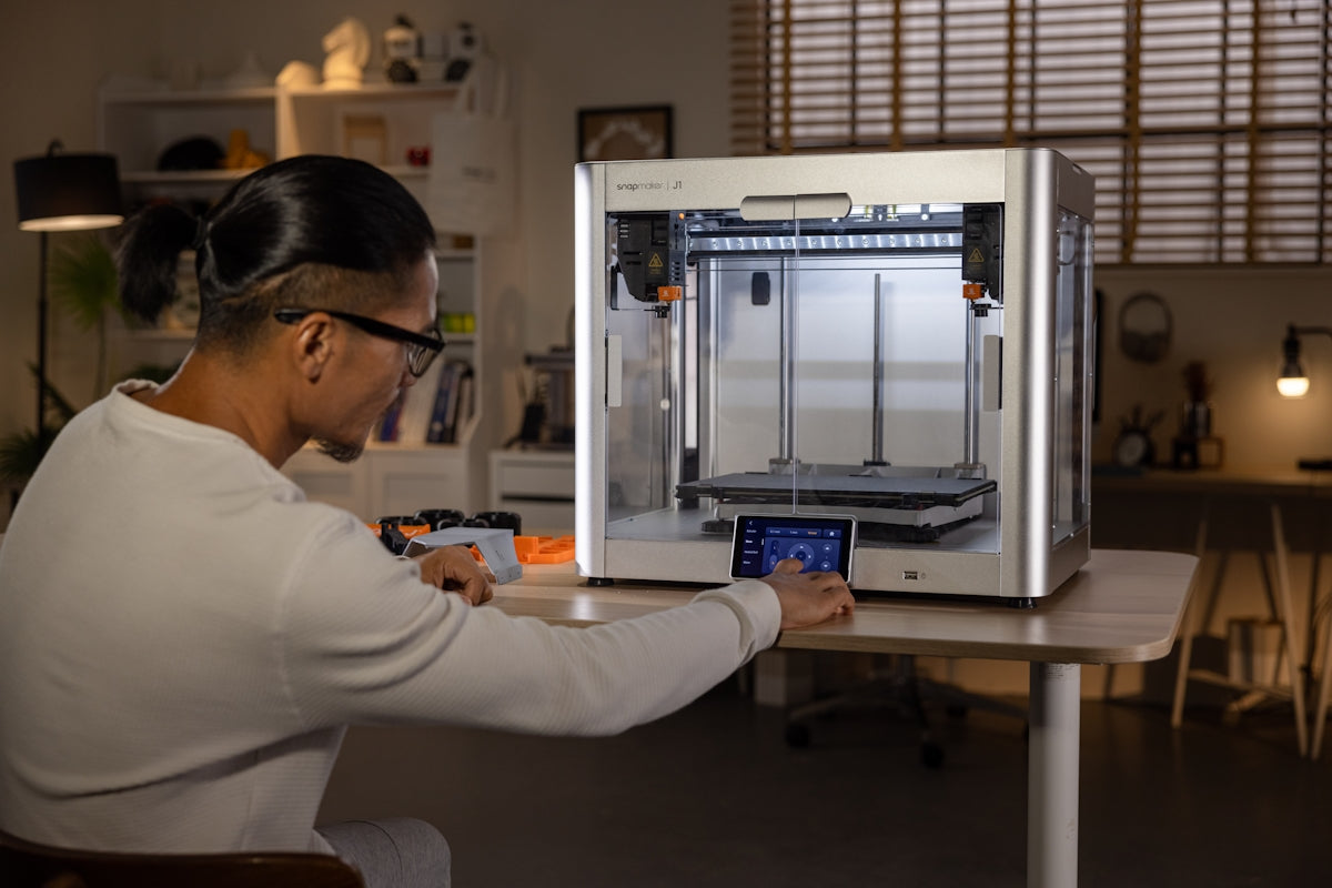 A woman is working on a 3D printer