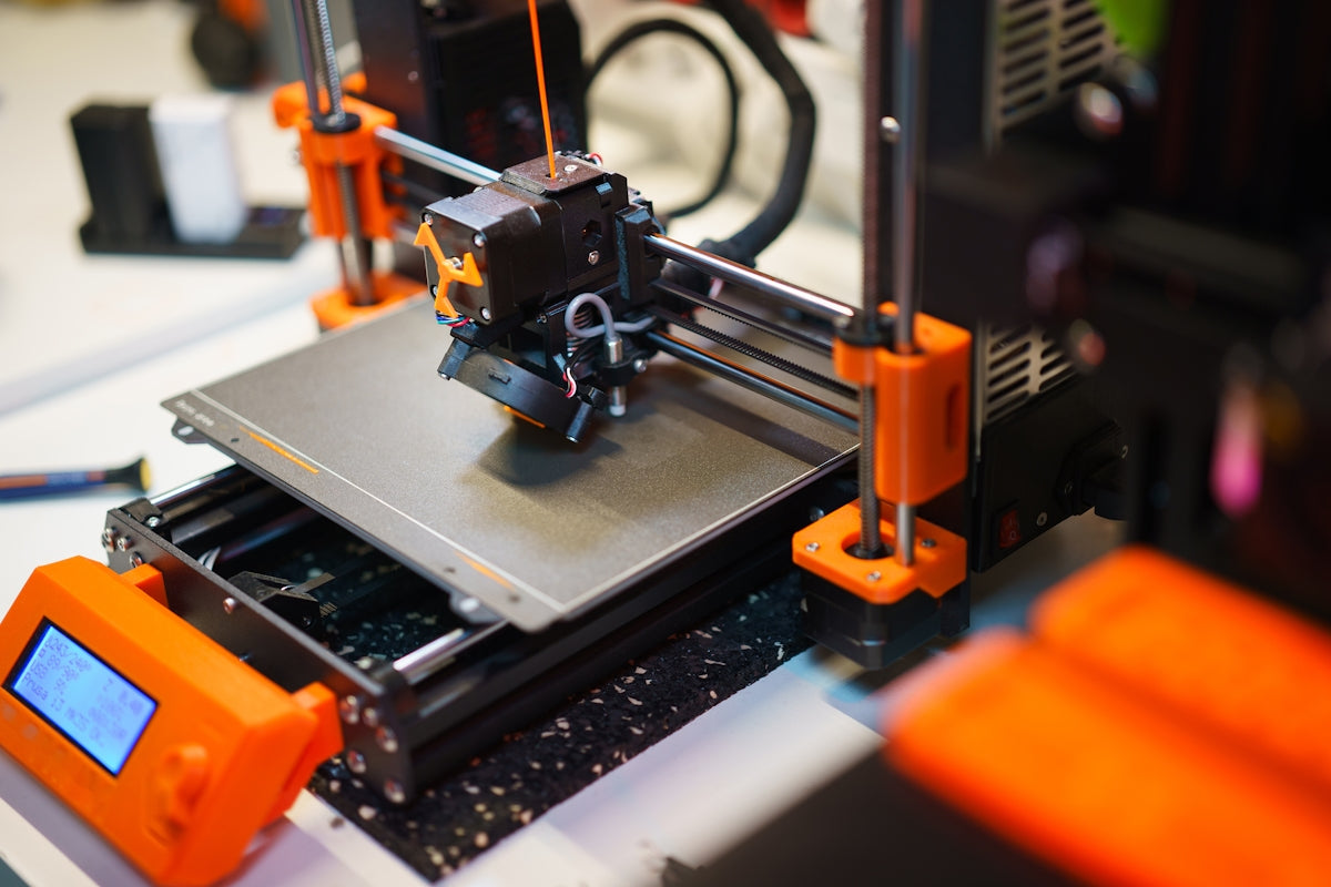 A 3D printer is shown in operation.